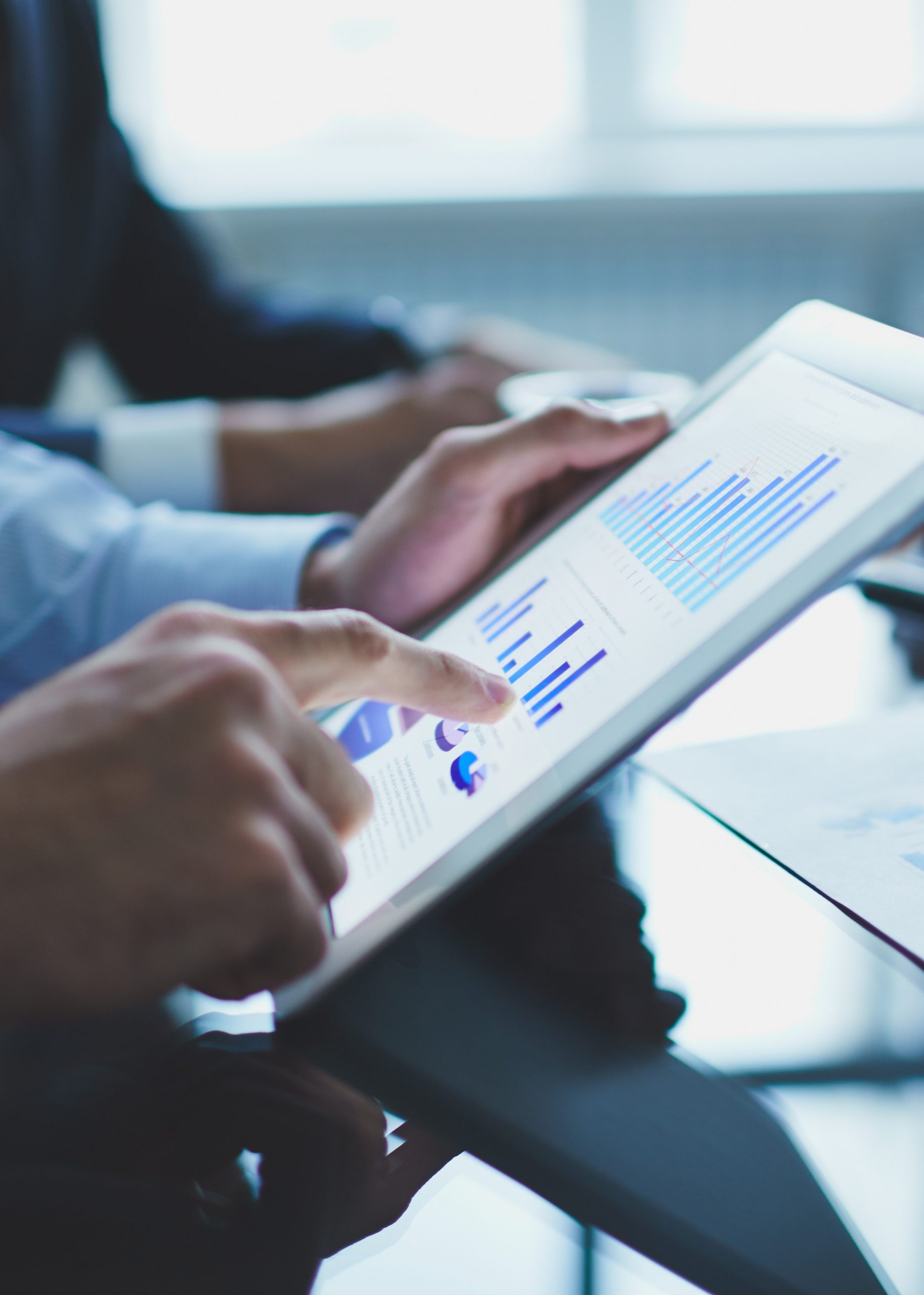 Image of businessperson pointing at document in touchpad at meeting